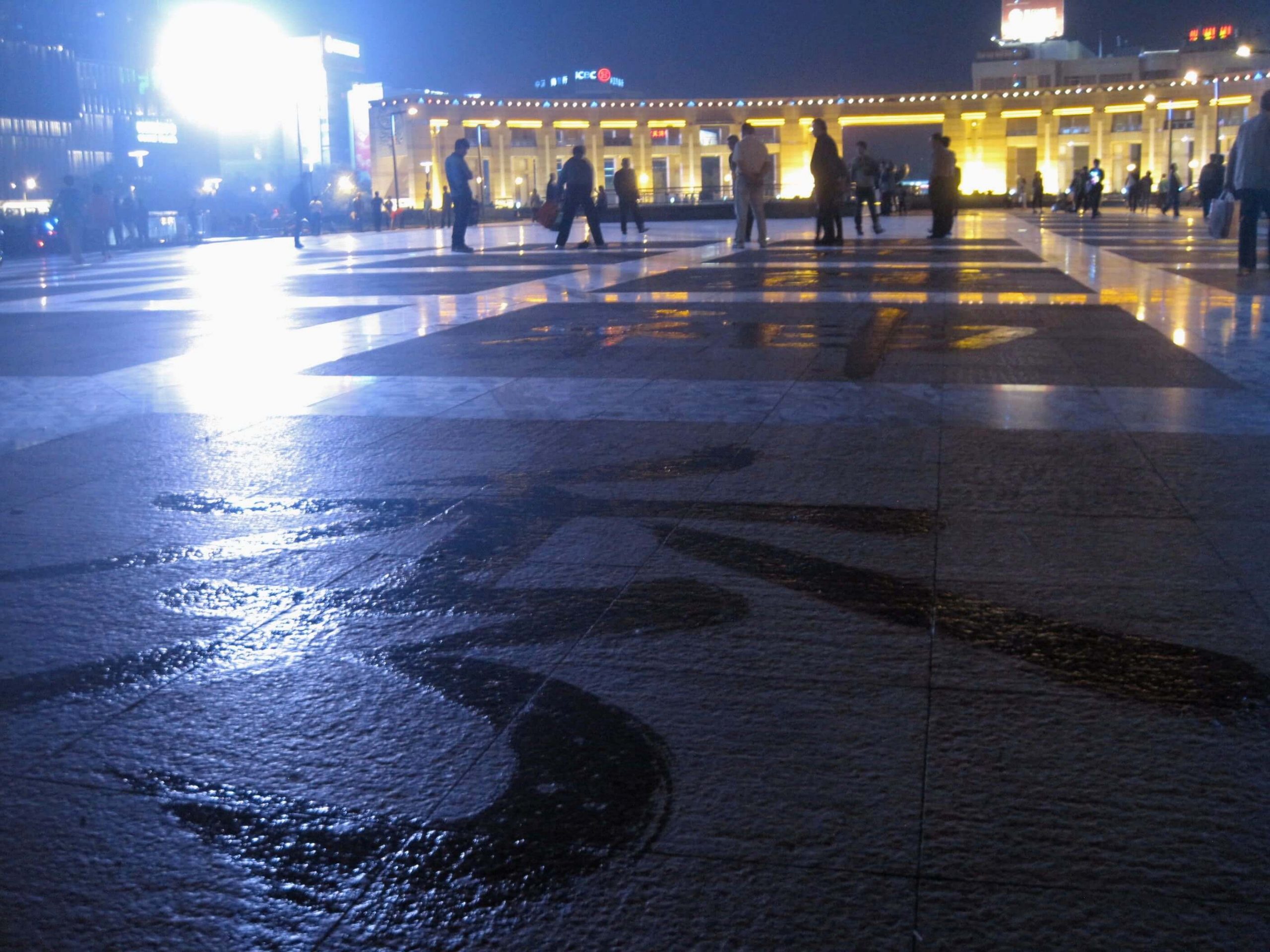 Trying to learn Mandarin from poetry written with a wet mop in a public square in Jinan, China. ©KettiWilhelm2014