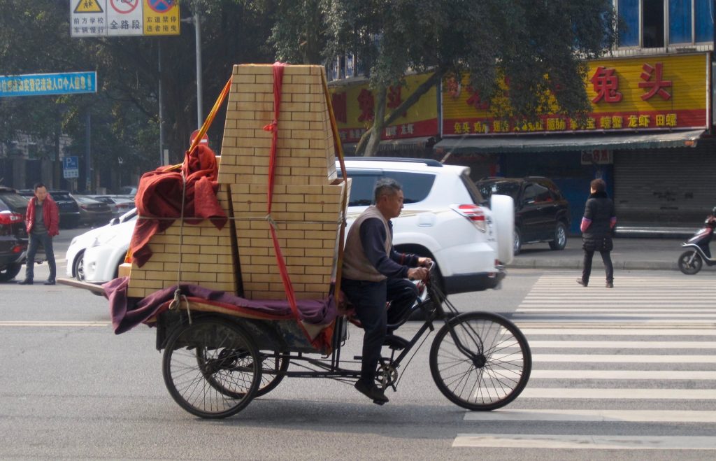 Offline shopping in China – a man delivering good on an overloaded bicycle. ©KettiWilhelm2015
