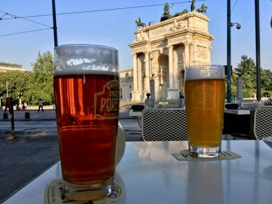 An aperitivo featuring two glasses of Poretti beer, with Milan's landmark the Arco della Pace in the background. ©KettiWilhelm2017