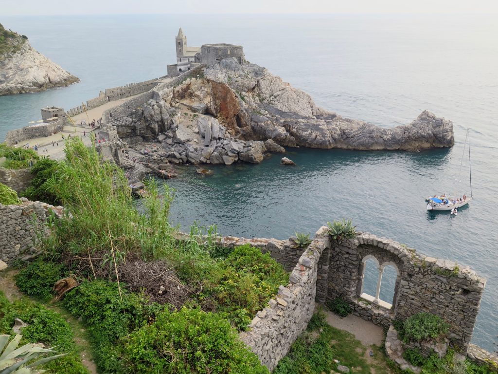 An overlook gazing down on the Ligurian Sea, on Italy’s West coast, including an ancient church and a window that’s all that remains of what was probably once a beautiful building. (In Cinque Terre, an extremely popular ferragosto destination.) ©KettiWilhelm2018