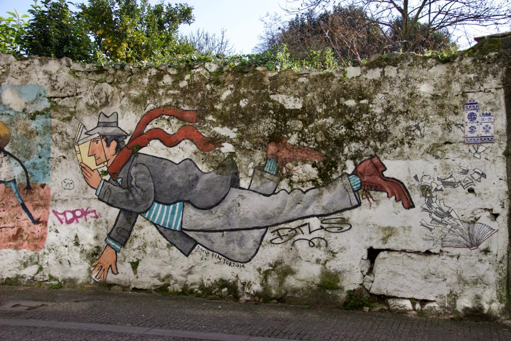 A street art painting of a flying man reading a book on Rua de Miguel Bombarda, Porto. ©KettiWilhelm2020