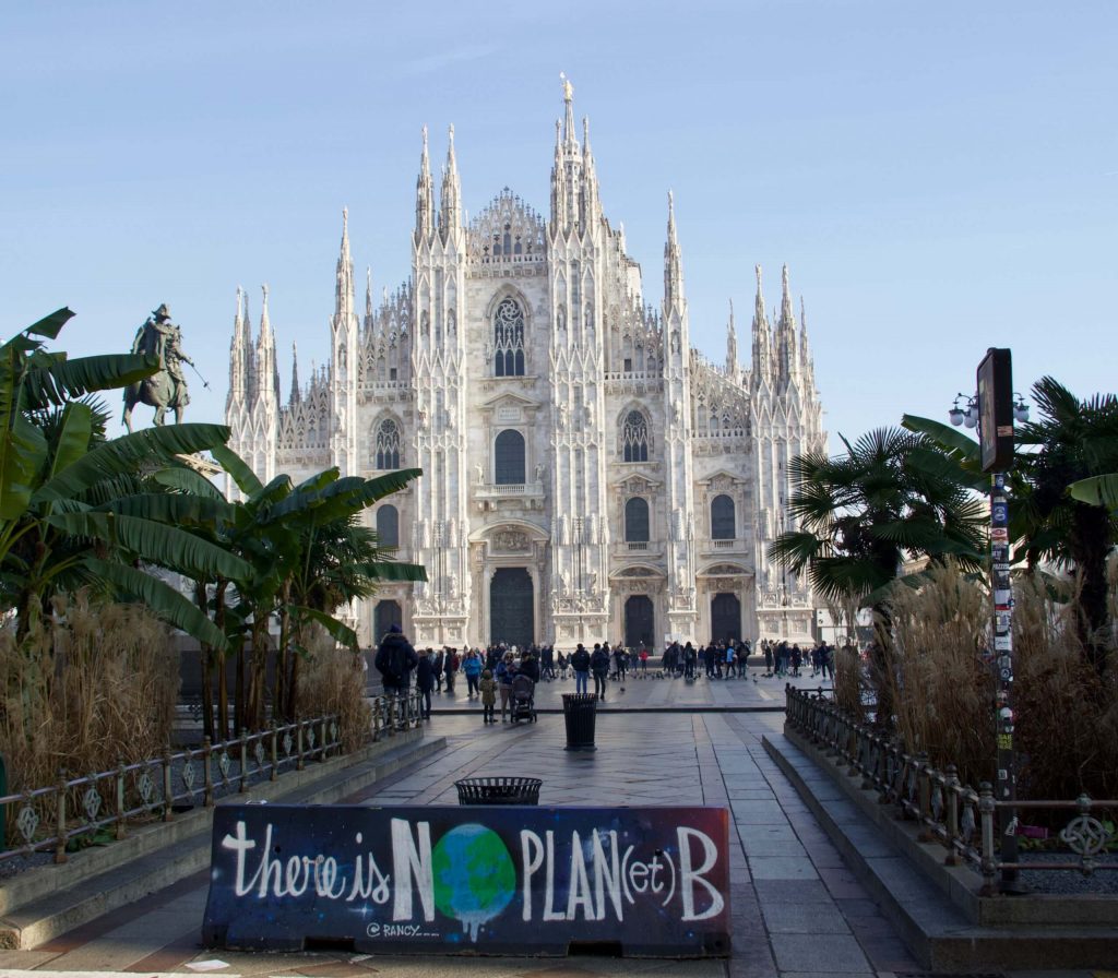 A painted traffic barrier in front of Milan, Italy's Duomo cathedral says "there is no planet b."