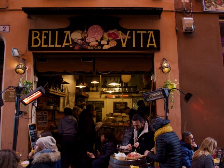 People gathered at a sidewalk restaurant in Bologna, Italy, for aperitivo. ©KettiWilhelm2020