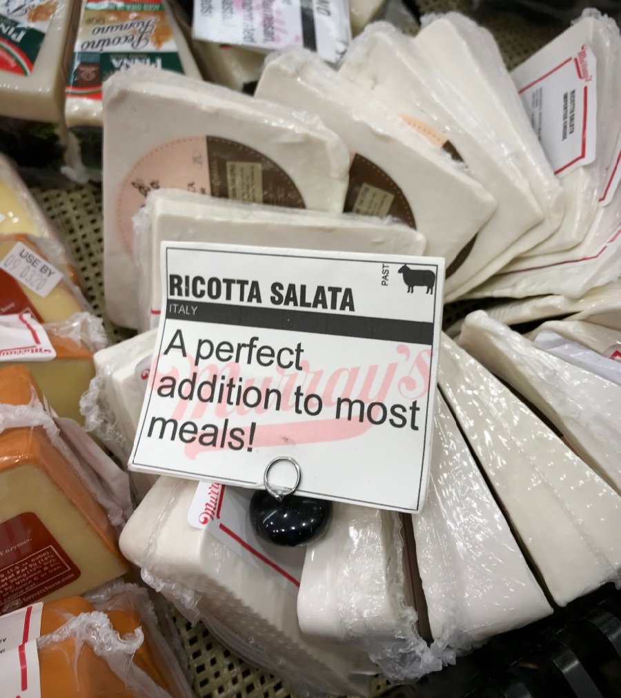 Ricotta salata cheese in a grocery store display that reads, “a perfect addition to most meals!” I love it with lots of pasta recipes. ©KettiWilhelm2020