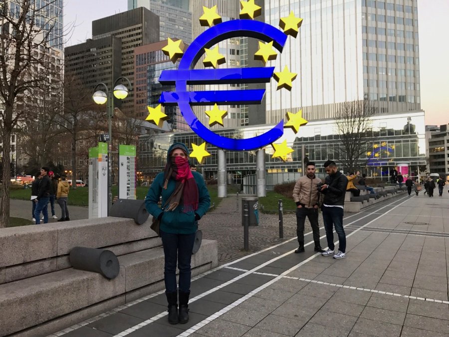 Standing in front of the brightly lit Euro currency sign in Frankfurt, Germany. ©KettiWilhelm2017