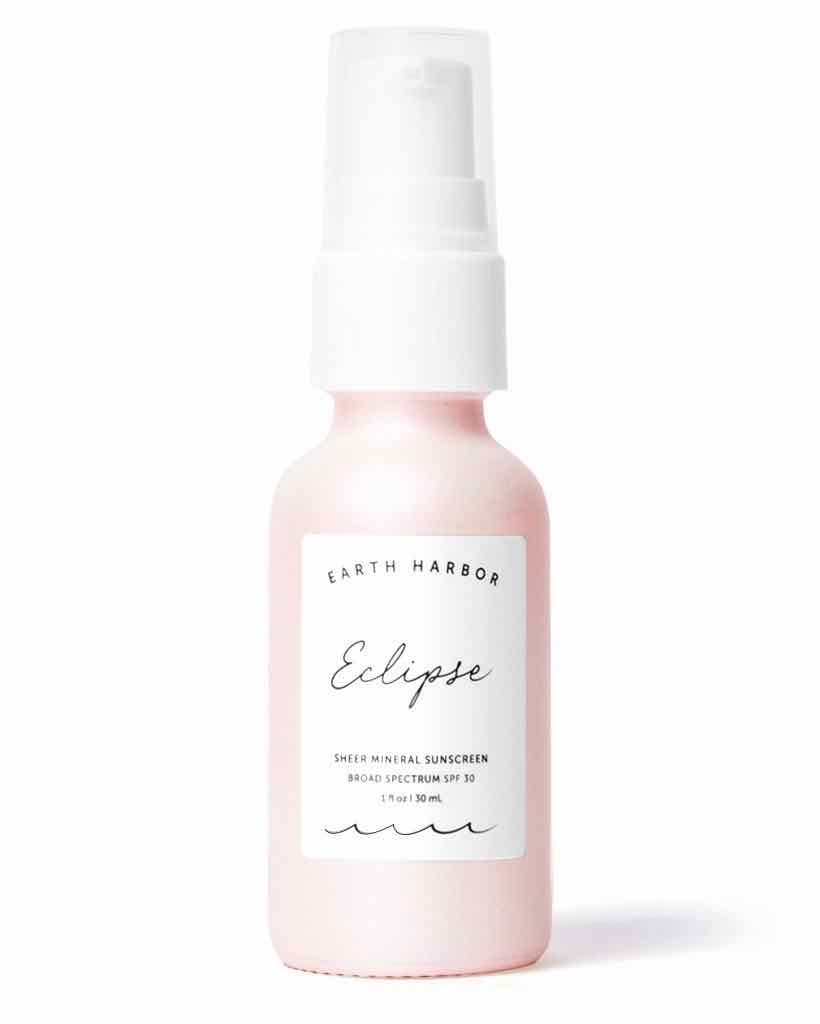 A brand image of Earth Harbor's ECLIPSE mineral sunscreen in a small, pink glass bottle, on a white background. 