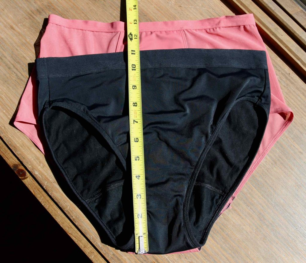 A comparison of Thinx’s Hi Waist style versus their French Cut: The French Cut is laid on top of the Hi Waist with a tape measure showing the difference in the rise between the two similar styles. ©KettiWilhelm2021