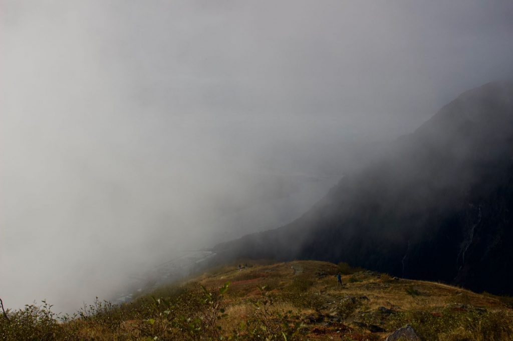 Thick fog rolling up the steep front of Mt. Roberts, obscuring the view of the city of Juneau below. ©KettiWilhelm2021