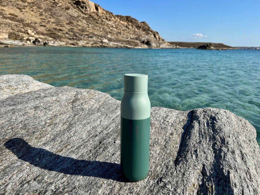My LARQ self-cleaning water bottle, sitting on a rock with the turquoise waters of the Mediterranean behind. ©KettiWilhelm2021