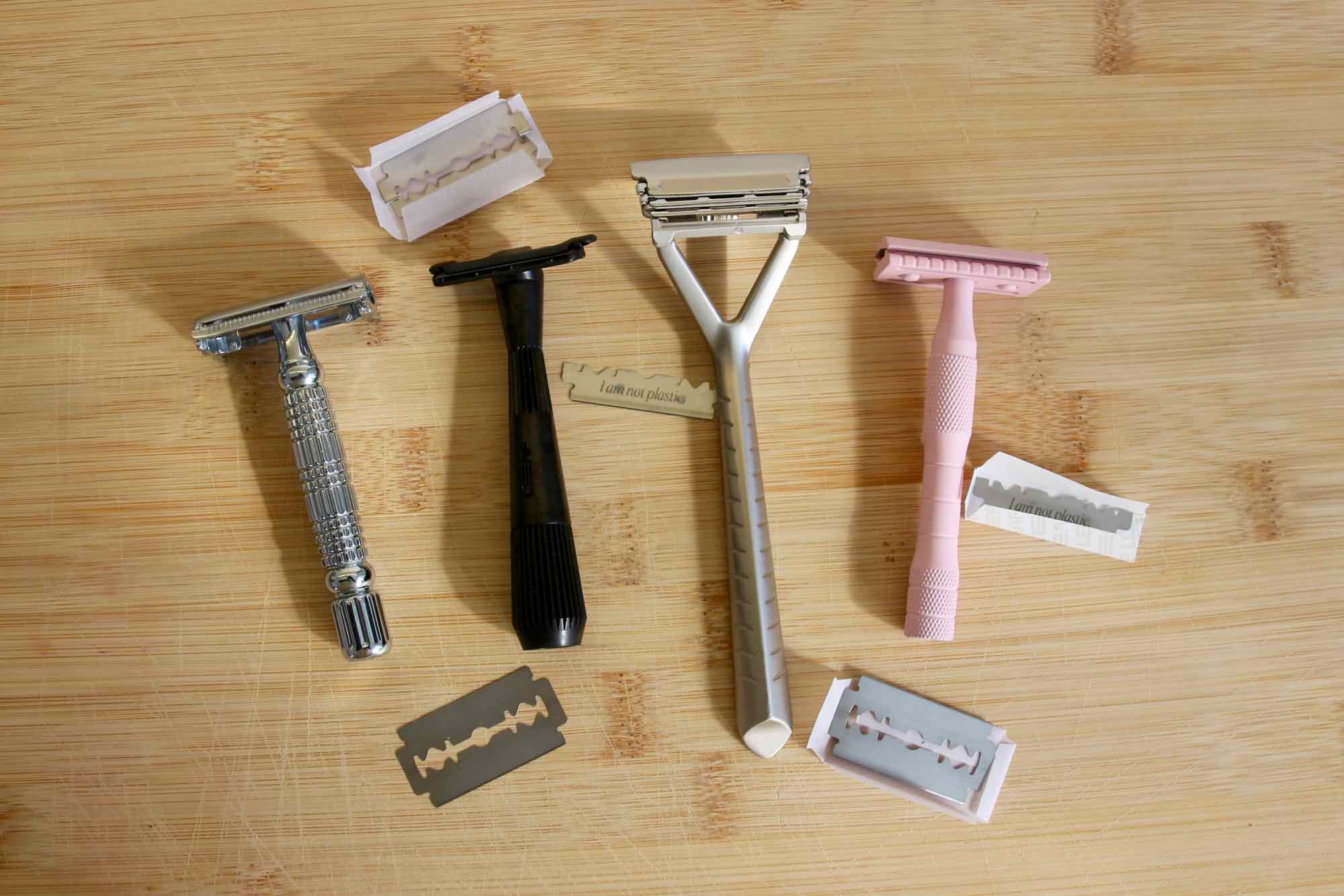 All four sustainable shaving options in this review. Left to right, on a wooden background: Albatross safety razor, Leaf Shave's Twig razor, Leaf's original safety razor alternative, and Well Kept. ©KettiWilhelm2021