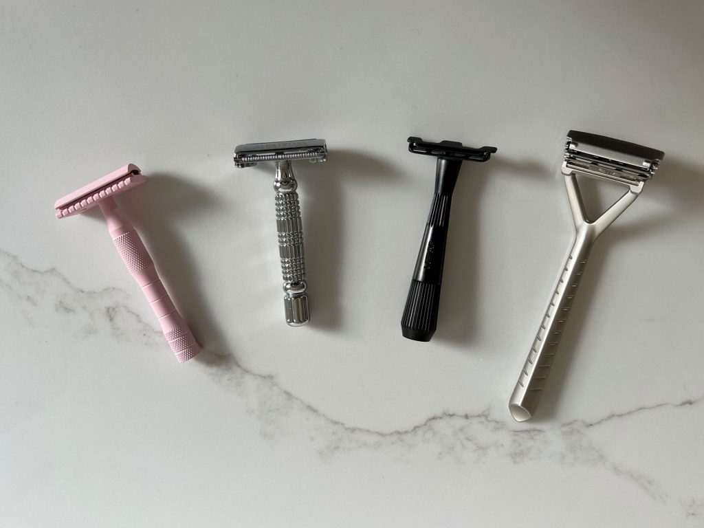 The four safety razors (and one safety razor alternative) sitting on a white marble counter top: Well Kept's safety razor, Albatross's butterfly razor, Leaf's Twig razor, and the original Leaf razor. ©KettiWilhelm2021