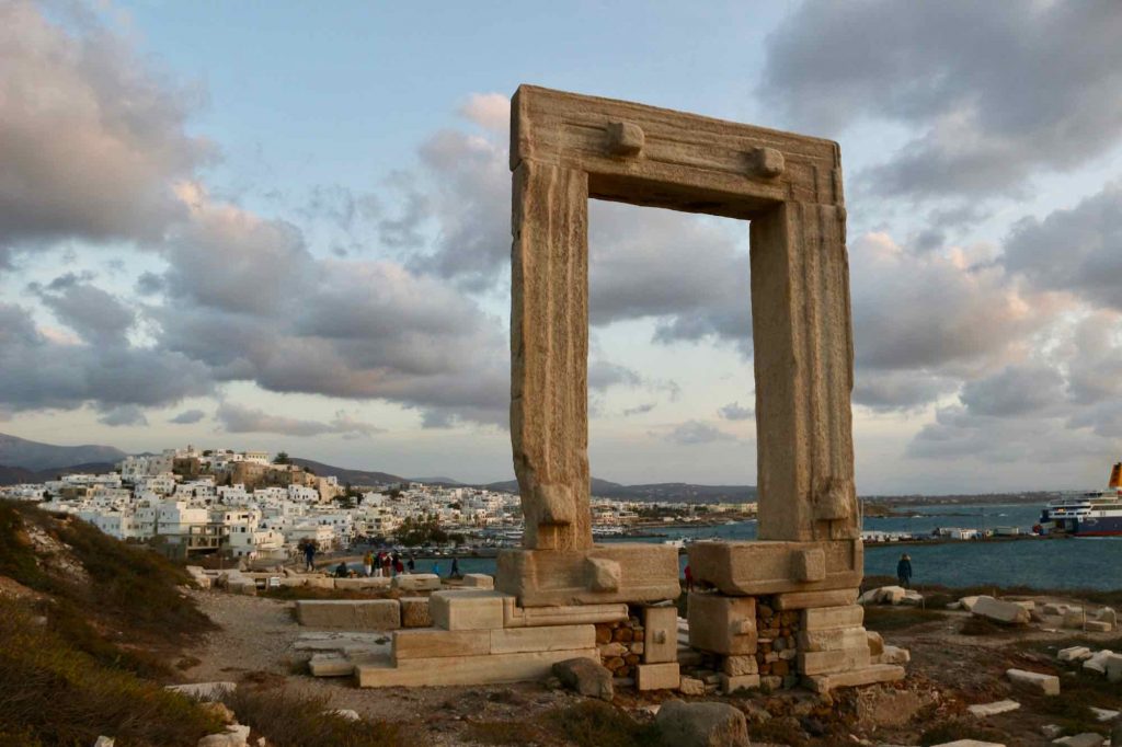 The symbol of the island of Naxos, Greece: The Temple of Apollo on a stormy, autumn afternoon, with the town of Hora and a ferry from nearby Paros behind it. ©KettiWilhelm2021
