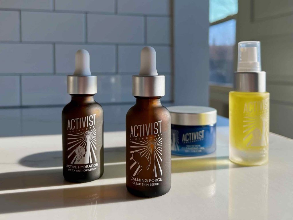Highlights of my zero-waste skincare routine from Activist Skincare: two refillable serums, and two refillable cleansing oils, all on a clean white marble counter top with a white tile background. ©KettiWilhelm2022