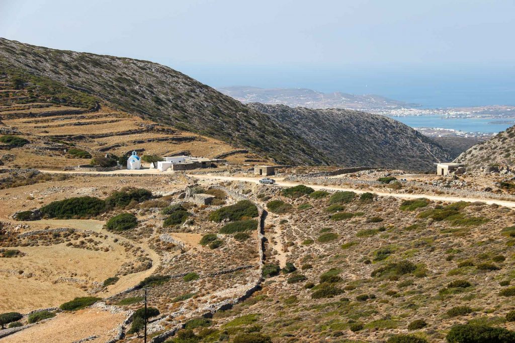 Dirt roads and hiking trails through the rural mountains of Paros, covered in brown vegetation, with the Mediterranean visible in the background. ©KettiWilhelm2022