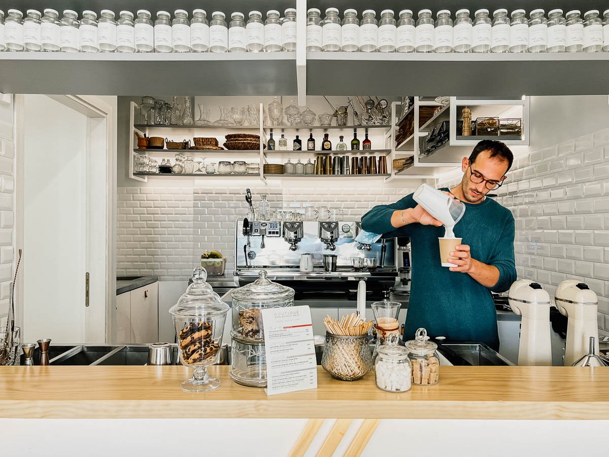 A barista at Boutique Ramantis Bros coffee shop on Paros, near the town of Aliki, prepares a coffee drink. ©KettiWilhelm2022