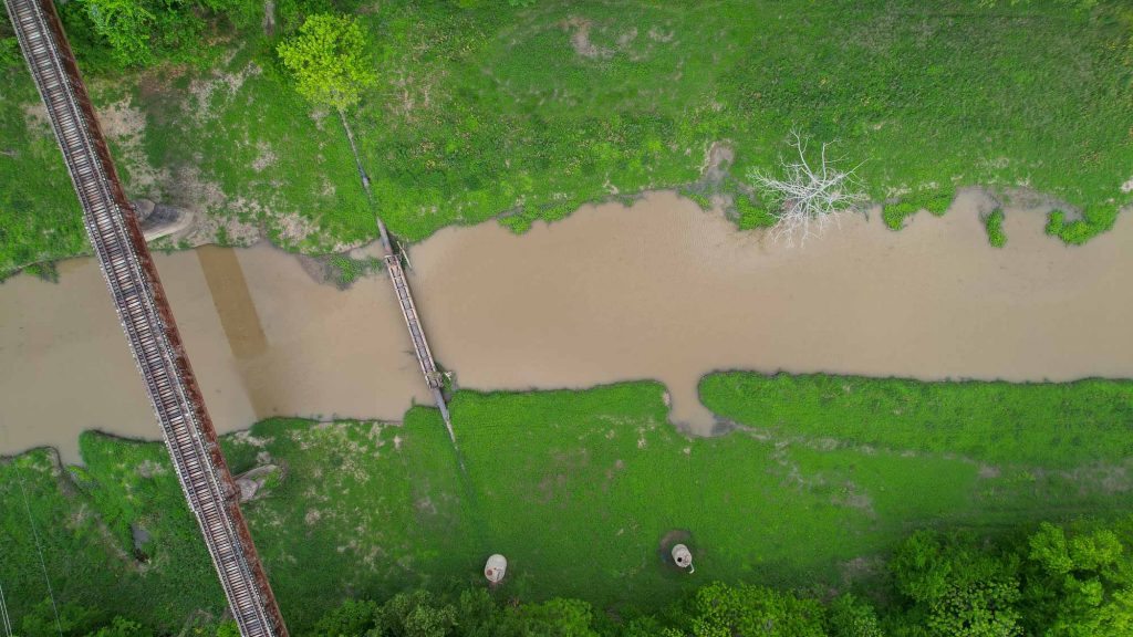 Aerial photo of a narrow section or tributary of the Mississippi River, near Clarksdale, Mississippi, with old train tracks crossing over it. ©ChristineLozada2022