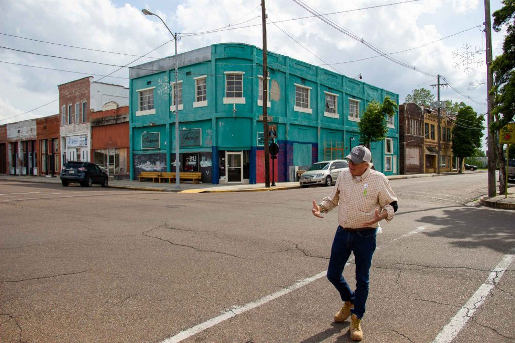 Bubba O’Keefe talking and walking backward while crossing an empty street in downtown Clarksdale, Mississippi. ©KettiWilhelm2022