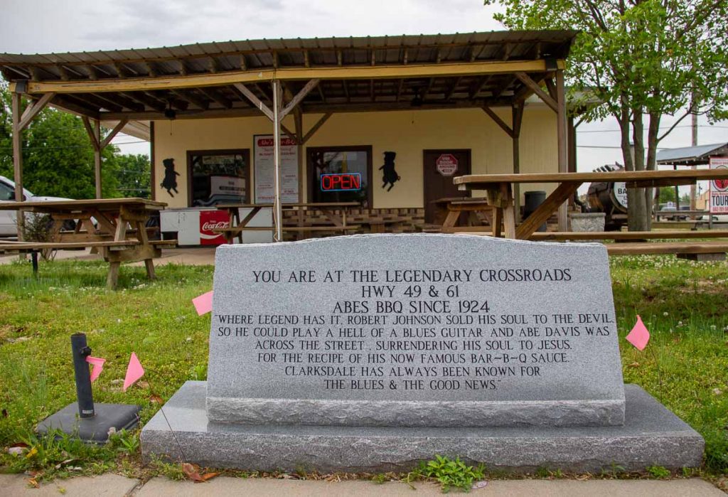 The stone marker in front of Abe’s BBQ, at the famous Crossroads of Highways 49 and 61, reads: “Where legend has it, Robert Johnson sold his soul to the devil so he could play a hell of a blues guitar and Abe Davis was across the street, surrendering his soul to Jesus for the recipe of his now famous Bar-B-Q sauce. Clarksdale has always been known for the blues & the good news.” ©KettiWilhelm2022