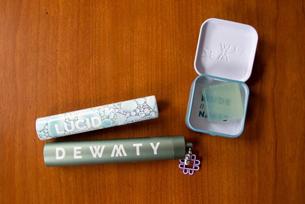 Plastic-free face wash powder and solid serum from Dew Mighty sitting on a wooden table. ©KettiWilhelm2022