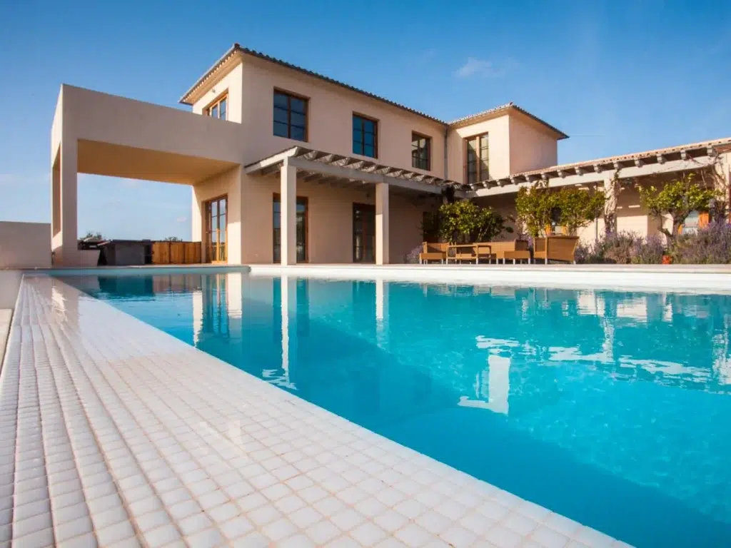 Bright blue water of the private pool at this villa in Mallorca, Spain, with the villa in the background.