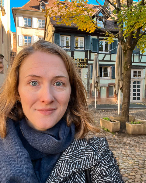 The author and photographer posing for a selfie in a quiet plaza in Strasbourg, France, after getting hit by a car. ©KettiWilhelm2023.