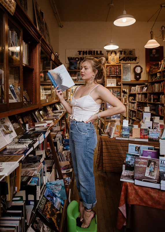 Sustainable clothing boutique owner Cordova Pleasants wearing a pear of DL1961 jeans in a bookstore in Juneau, Alaska. 