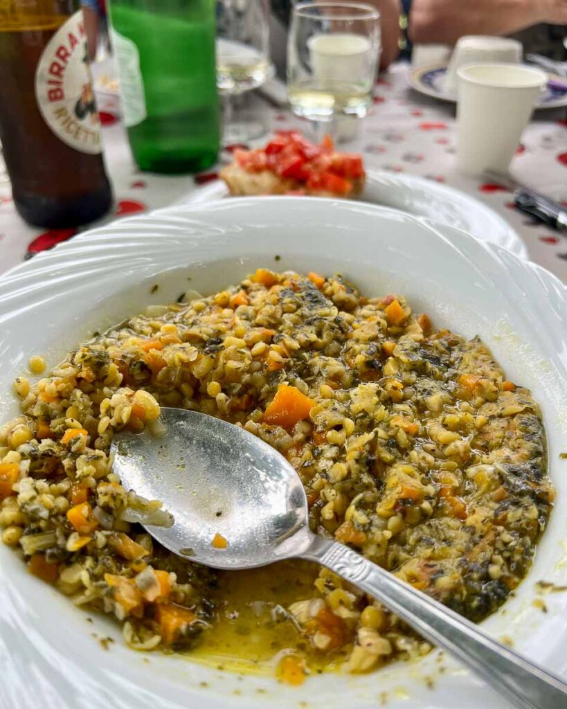 A plate of lentils to eat with the fresh olive oil from the olive groves behind us at this stop on our electric bike tour in Italy's Marche region. ©KettiWilhelm2023