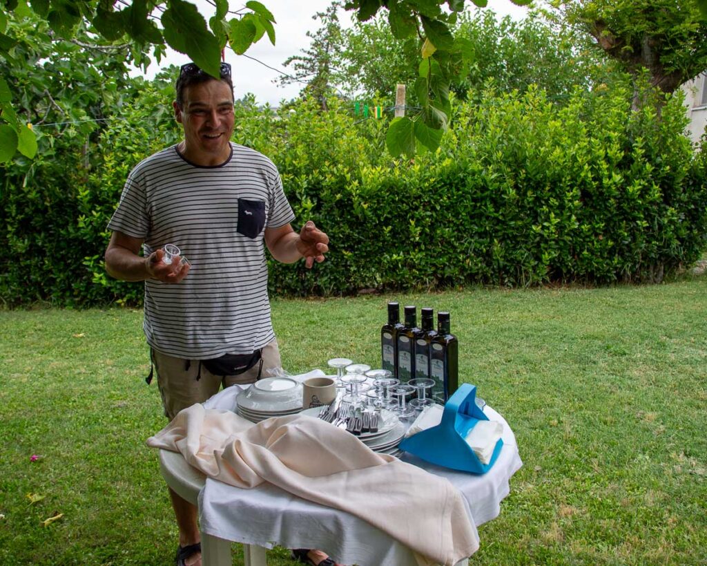 Organic olive oil farmer Giorgio Nobile demonstrates how to taste olive oils in his backyard in March, Italy, during our ebike tour. ©KettiWilhelm2023