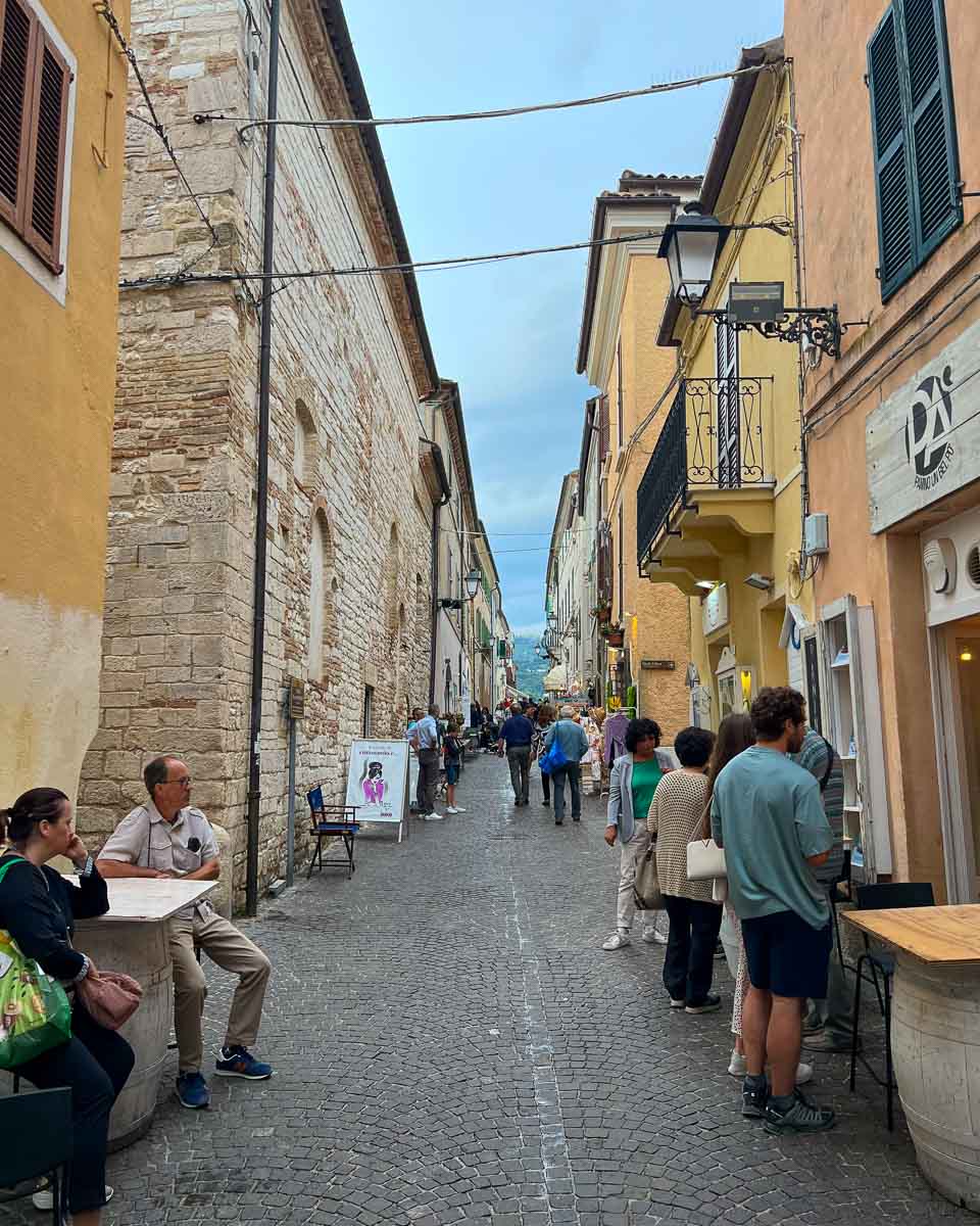 Tourists and local mingle in a narrow street in the center of Sirolo, the beach town where our bike tour in Italy ended. ©KettiWilhelm2023