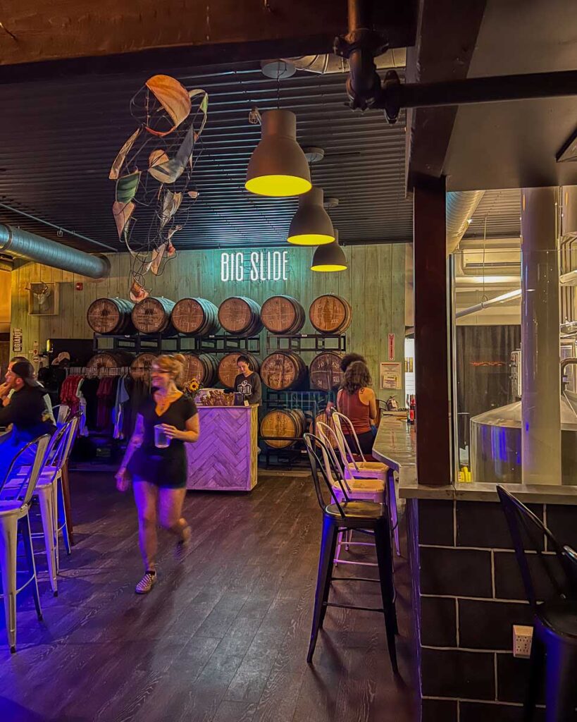 The cozy, colorful yet dark bar seating area inside Big Slide Brewery in the Adirondack town of Lake Placid, New York. ©KettiWilhelm2023