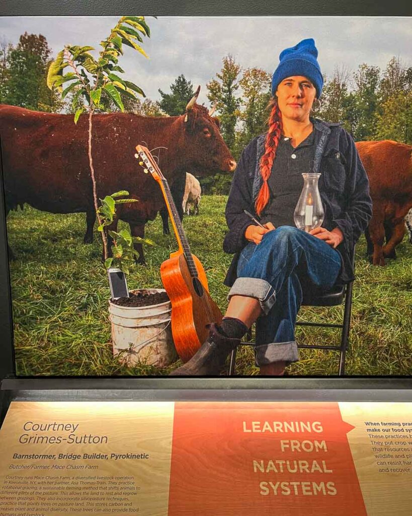 Courtney Grimes-Sutton, one of the founders of the sustainability-focused farm and ranch Mace Chasm Farms, on the wall of the Wild Center’s inspiring Climate Solutions exhibit. ©KettiWilhelm2023