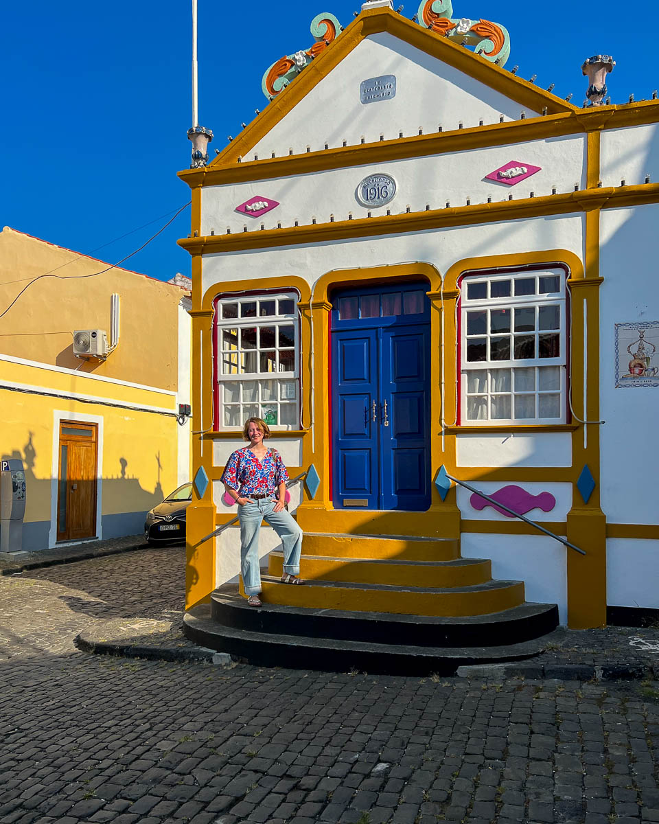 Sustainable travel writer Ketti Wilhelm, of Tilted Map, standing in front of an imperio. Visiting one of these iconic Holy Ghost chapels should be on any Terceira itinerary. ©KettiWilhelm2024