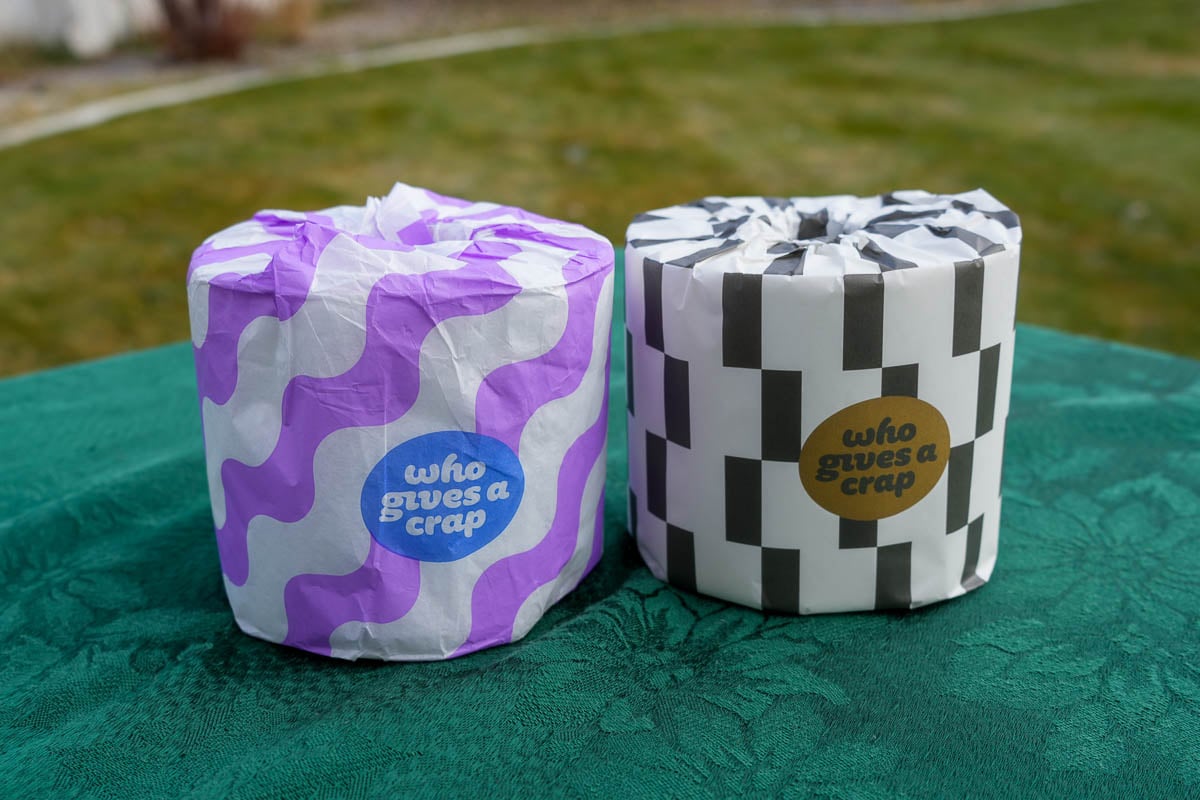 Comparing bamboo vs recycled toilet paper from Who Gives A Crap – displayed on a green table cloth outdoors. ©KettiWilhelm2024
