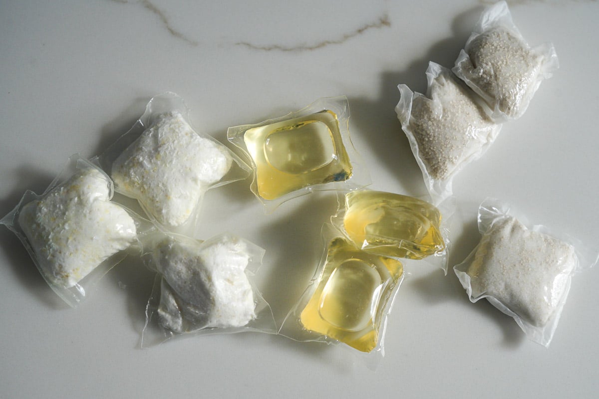 A close-up of several types of Dropps laundry pods, which are compared in this review, sitting on the writer's kitchen countertop. ©KettiWilhelm2025