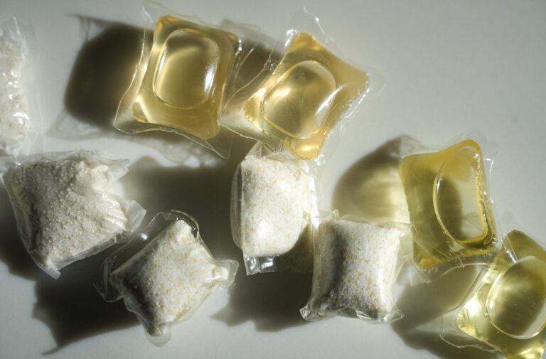Several types of Dropps laundry pods, which are coated in a PVA film, like most laundry detergent pods and strips, sitting on the writer's kitchen countertop. ©KettiWilhelm2025