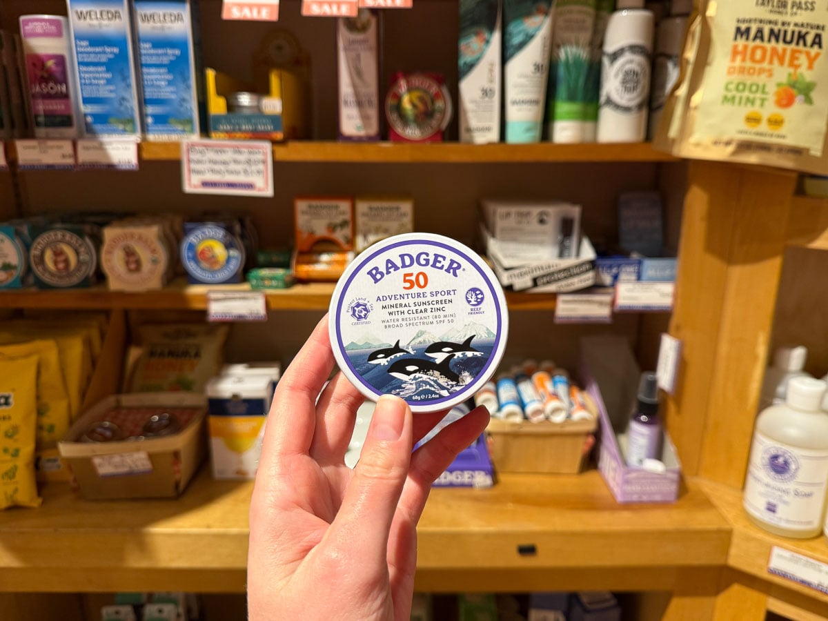 Holding a tin of Badger's plastic-free, chemical-free, water-resistant SPF 50 sunscreen that I bought in a local store for this review. ©KettiWilhelm2026