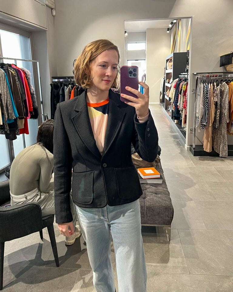 Trying on a Yves Saint Laurent blazer in a designer consignment store in Milan, Italy. ©KettiWilhelm2025