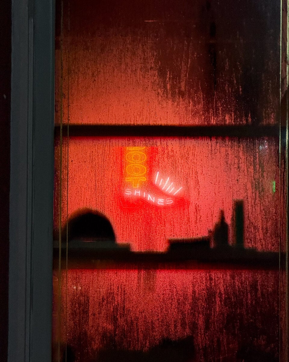 A red neon sign that read "boot shines" obscured by condensation on the window of a boot store in downtown Franklin, Tennessee. ©KettiWilhelm2026