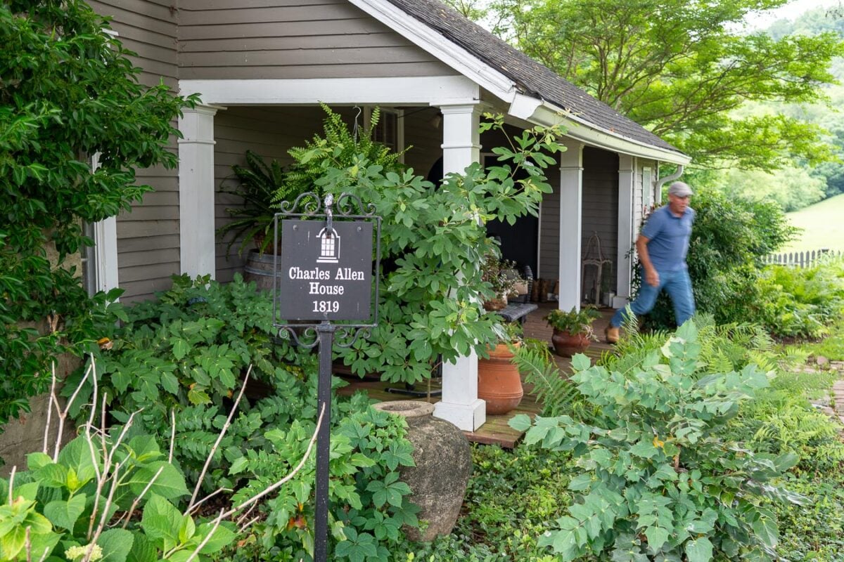 Alpaca farmer Doug Coleman rushes out of his historic home, with a sign in front labeling it the Charles Allen House, built in 1819, near downtown Franklin, Tennessee and Leiper's Fork. ©KettiWilhelm2026
