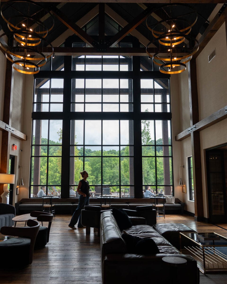 Hotel lobby with big windows showing green countryside at Southall Farm & Inn, a uniquely sustainable resort and working farm in Franklin, Tennessee. ©KettiWilhelm2026