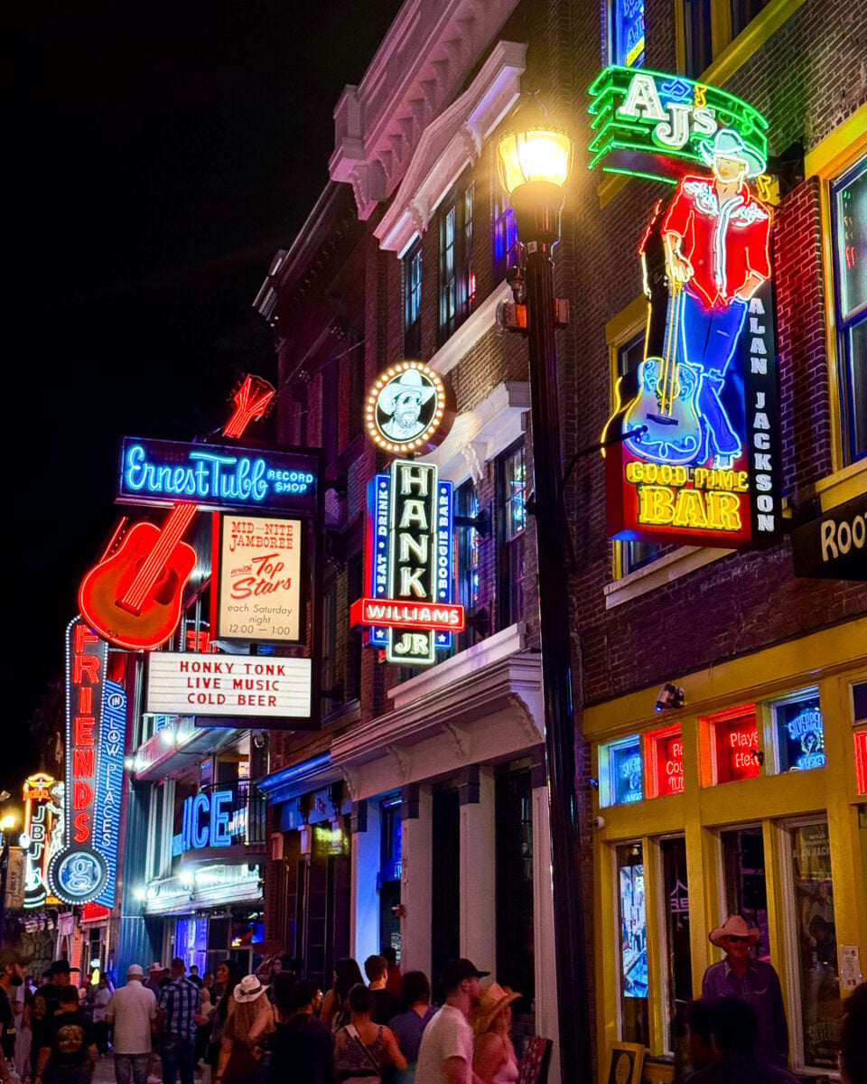Neon lights advertising bars and live music on busy Broadway Street, full of people, in downtown Nashville, Tennessee. ©KettiWilhelm2026